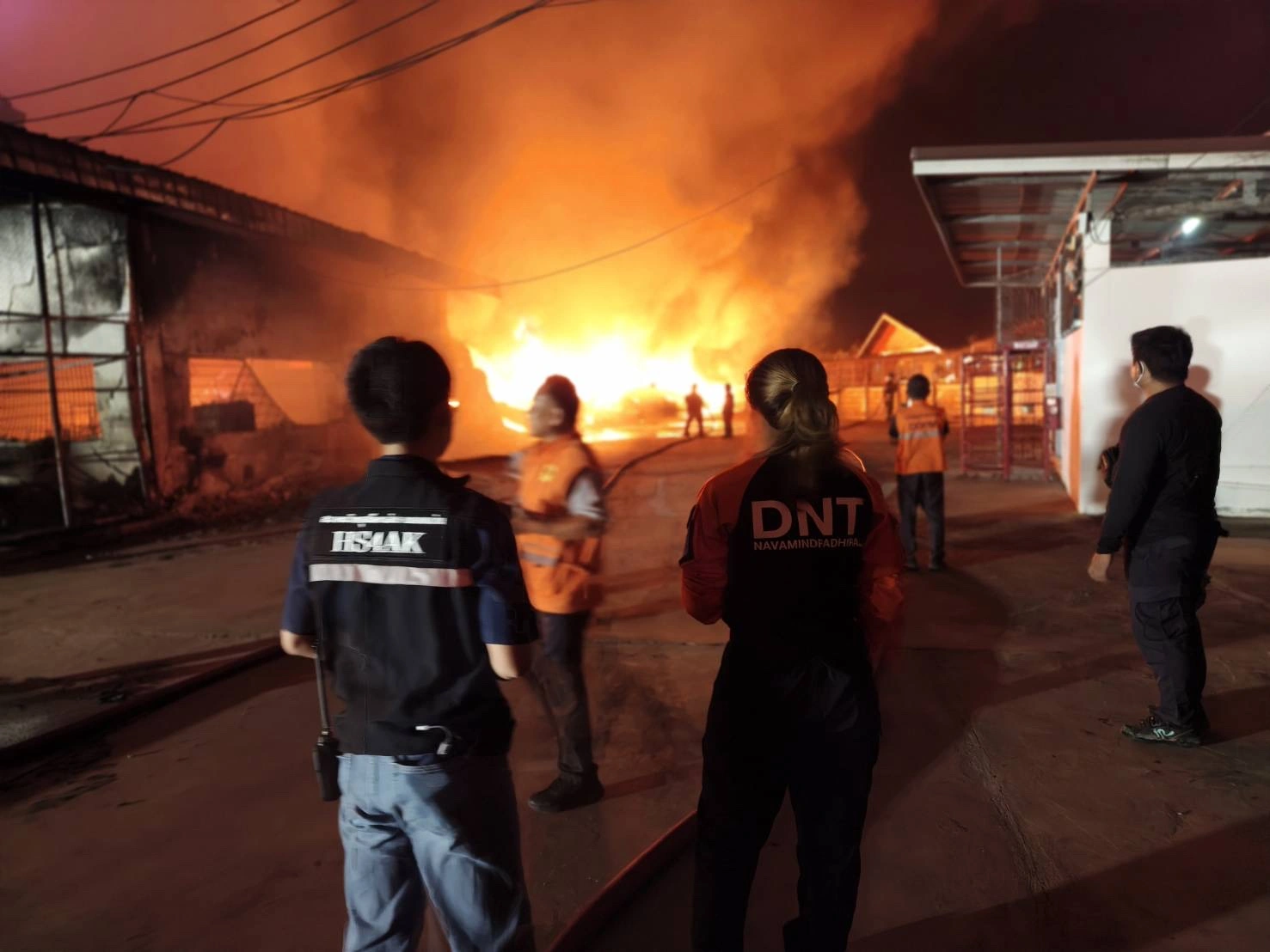 Responders watching a structural fire at night